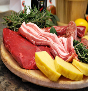 Tagliere con carne, pancetta, salsiccia e fette di polenta da cuocere ai ferri